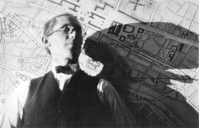Le Corbusier, hacia 1925, fotografiado delante de una imagen del Plan Voisin para Par&iacute;s. Fondation Le Corbusier, Par&iacute;s.