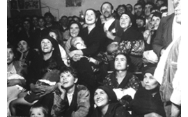 P&uacute;blico de una sesi&oacute;n de cine de Misiones. Al fondo, en el centro, el proyector port&aacute;til. Foto atribuida a Jos&eacute; Val del Omar. Biblioteca Nacional, Madrid